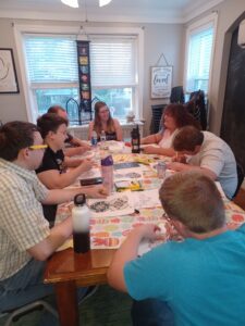 young people sitting around a table discussing faith and coloring.